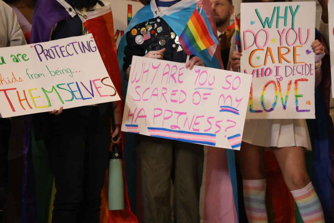 People hold trans rights signs at the Kentucky Capitol Rotunda for the 2023 Fairness Rally