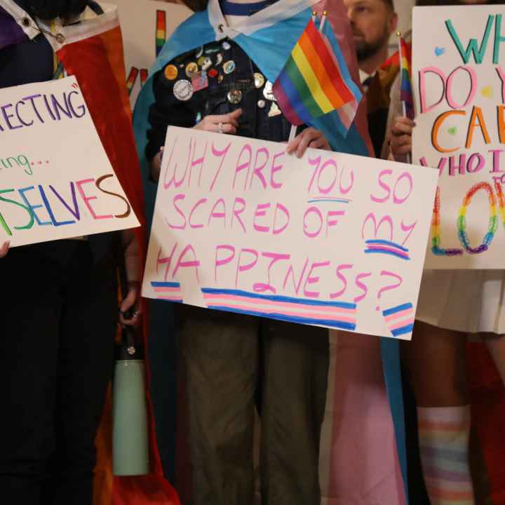 People hold trans rights signs at the Kentucky Capitol Rotunda for the 2023 Fairness Rally